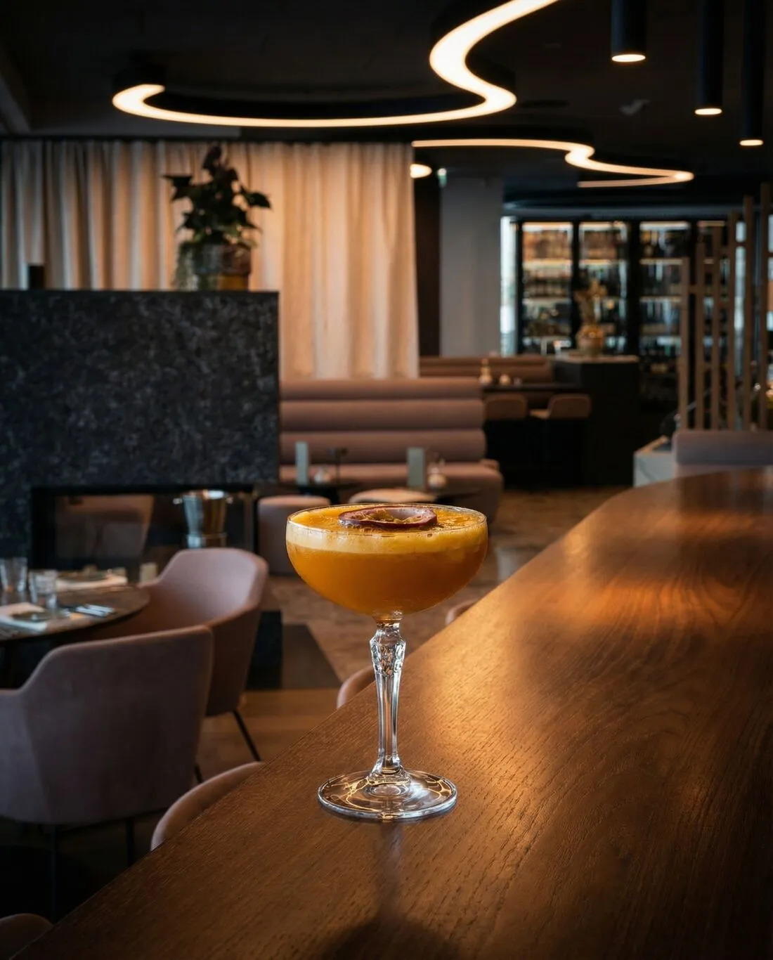 Passionsfrucht-Cocktail auf der Bar, dahinter die Lounge