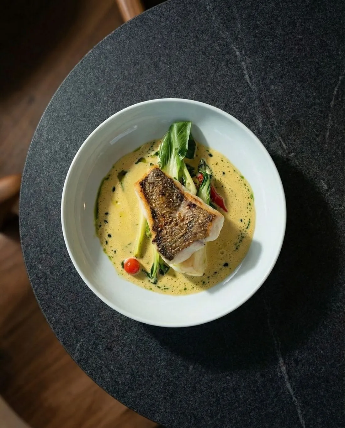 Gebratenes Fischfilet mit Pak Choi in heller Sauce, von oben